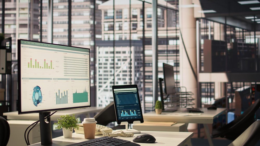 Desktop monitors displaying live sales and inventory dashboards in a modern office